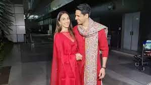 Sidharth Malhotra and Kiara Advani, newlyweds, pose for photographers as they exit the airport holding hands and wearing matching red outfits
